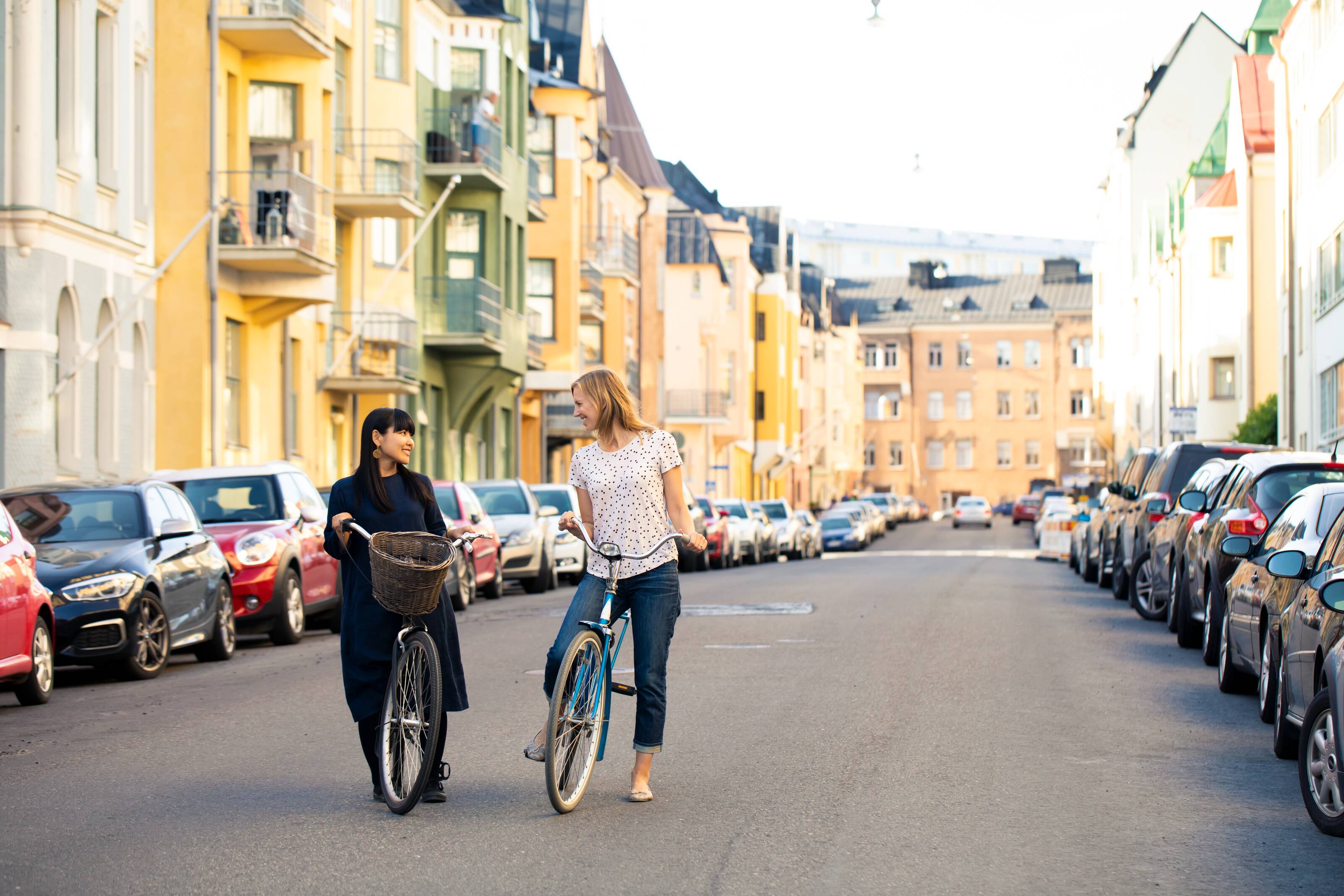 Women cycling on a colorful street.