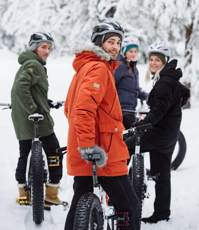 A group of people fat-biking in the snow.