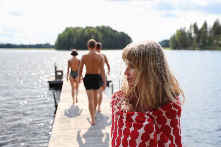 A group of people in bathing suits on a dock.