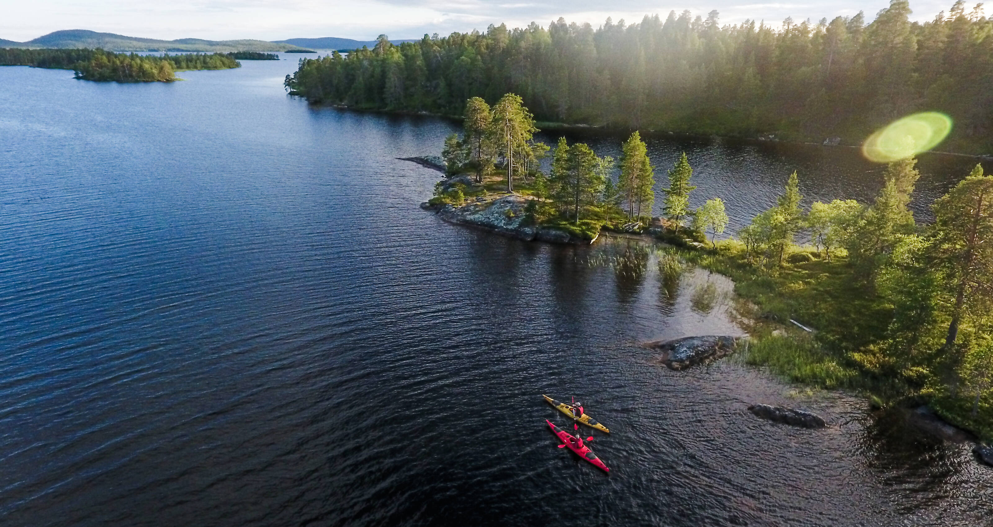 An aerial view of the Lake Inari and people canoying during the summer.