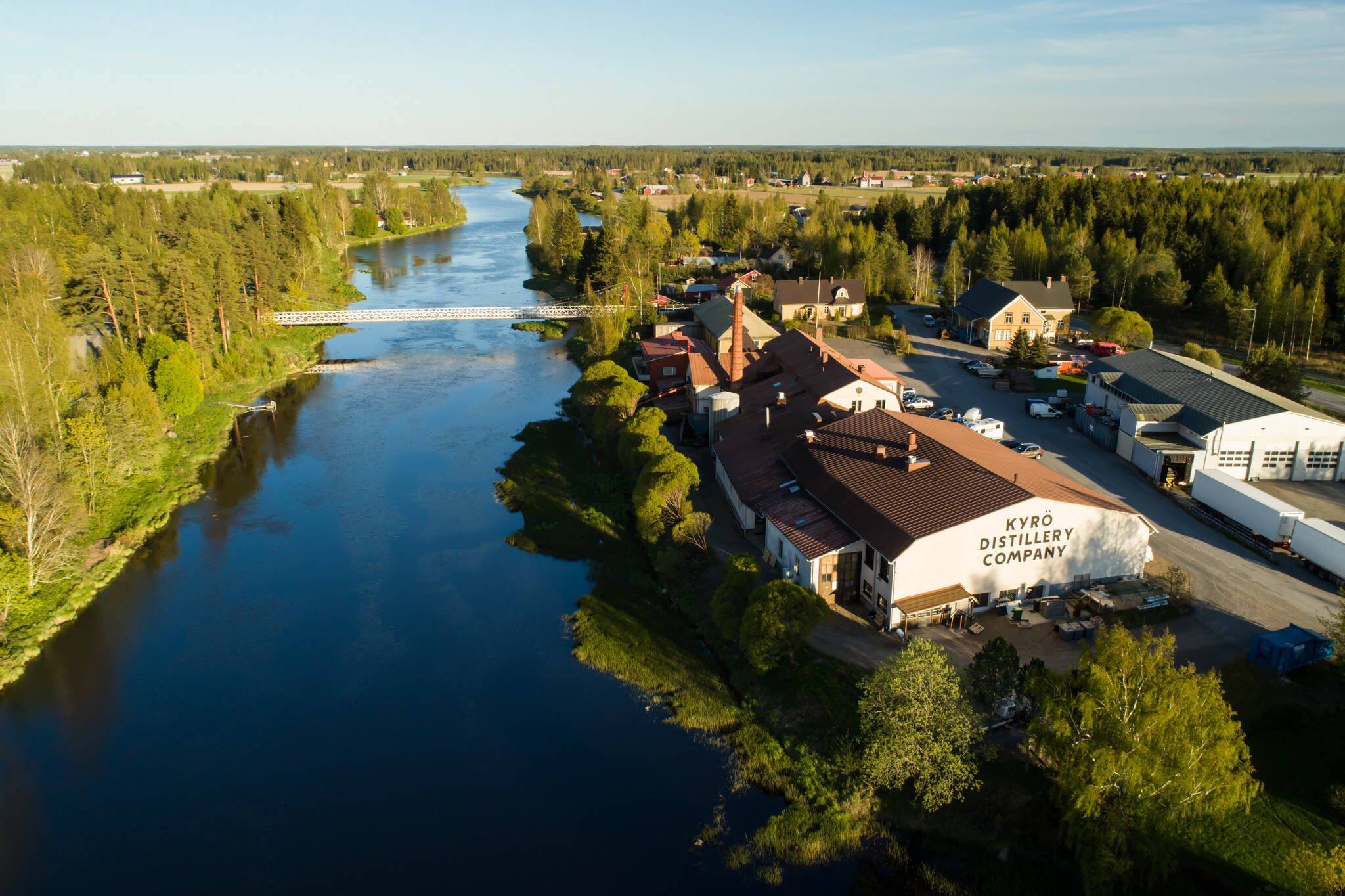 Birds eye view of Kyrö distillery and a river next to it on a sunny summer day