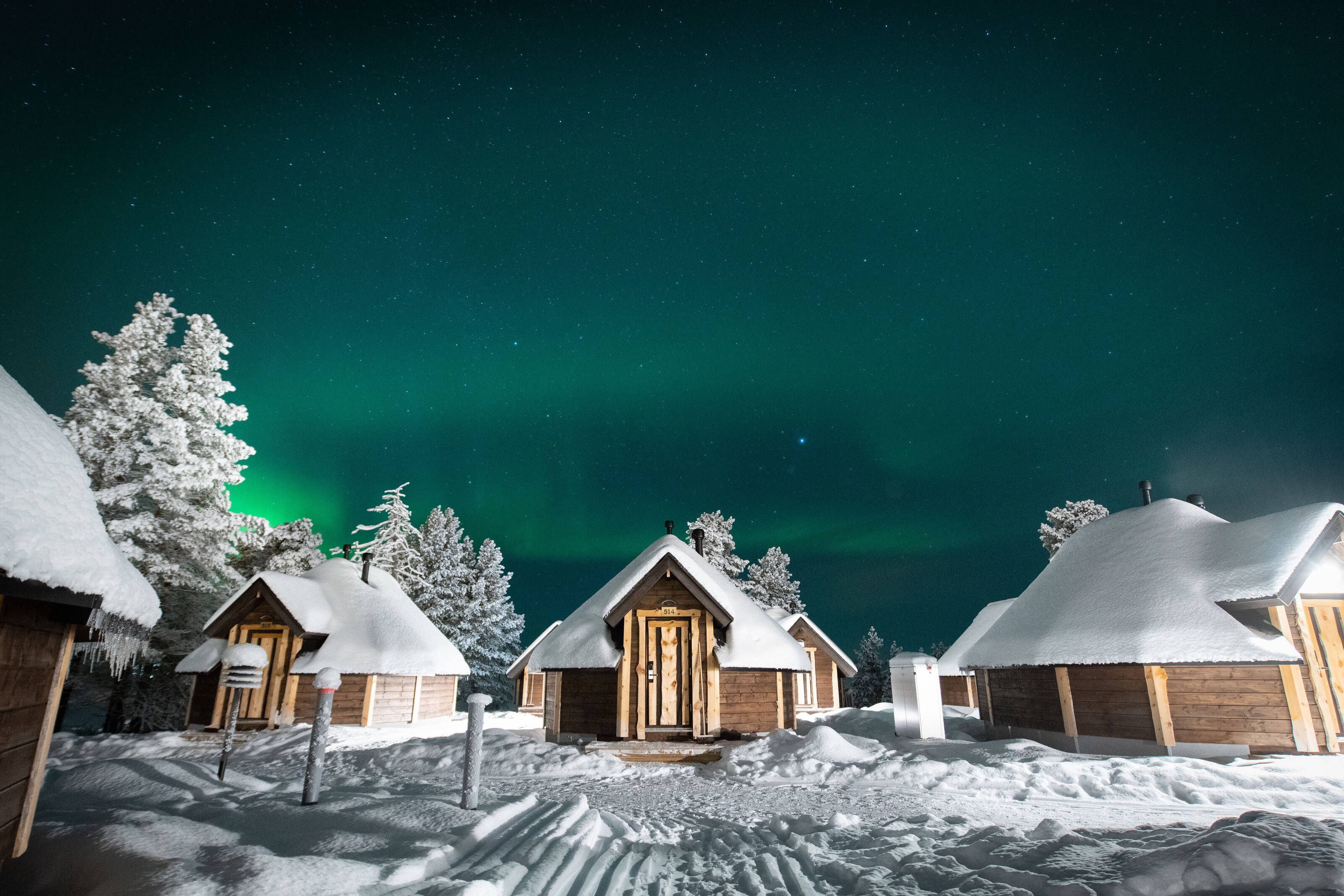 Snow-covered huts in the wilderness in the Lapland under the Norhern Stars.