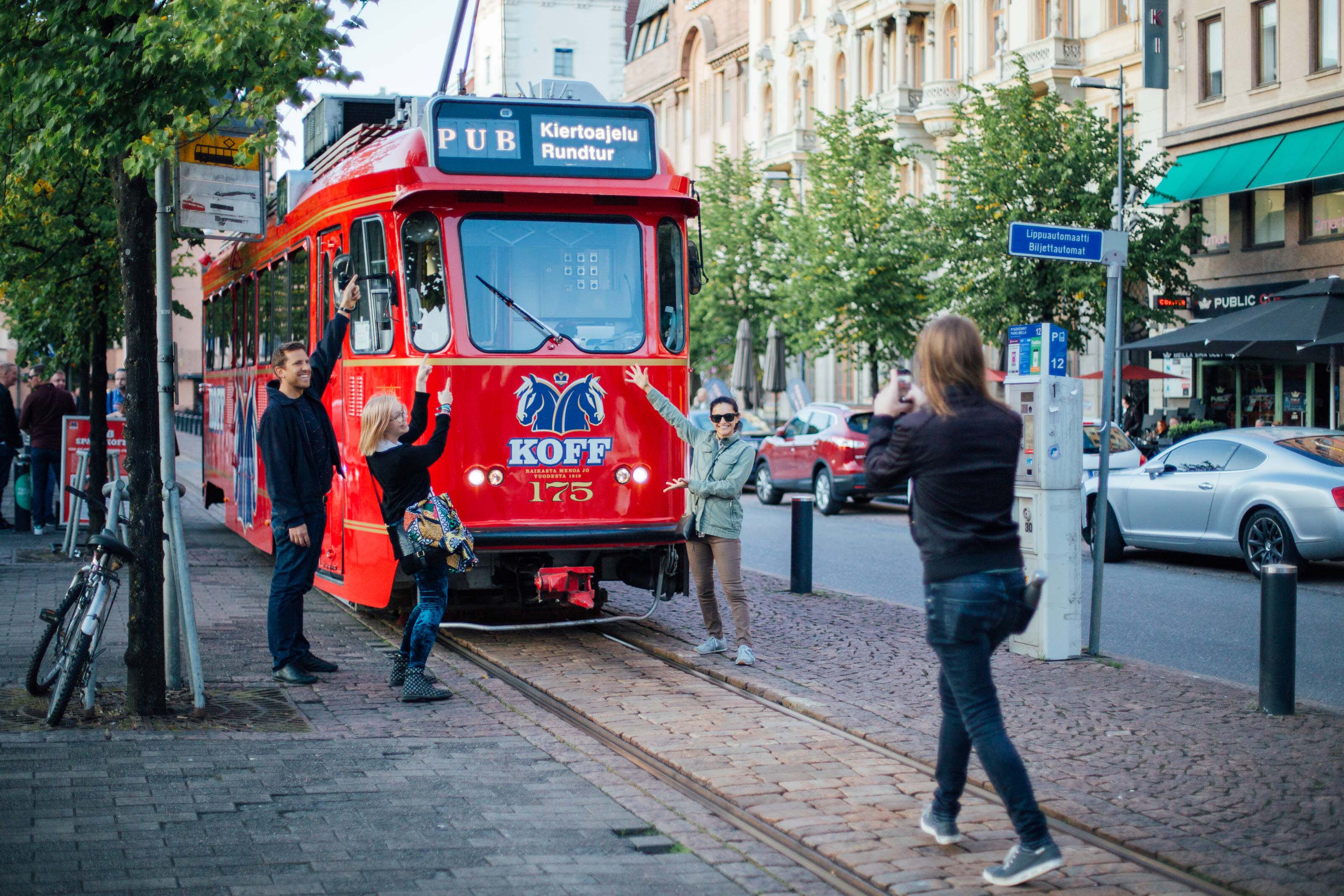 People in front of a red tram in Helsinki