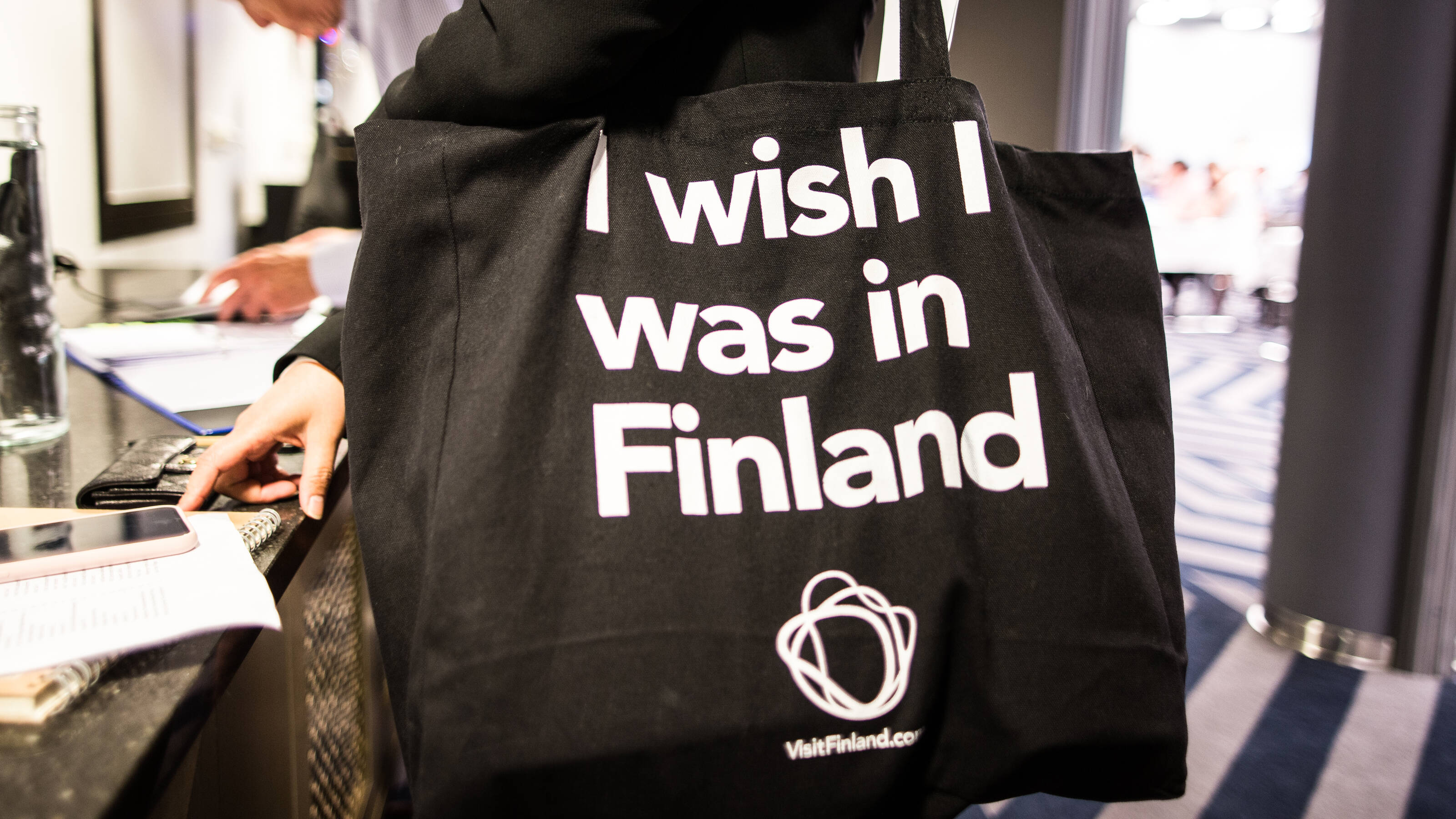View of a black tote bag with the text "I wish I was in Finland" and Visit Finland logotype.