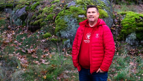 A man in red jumper standing in the forest