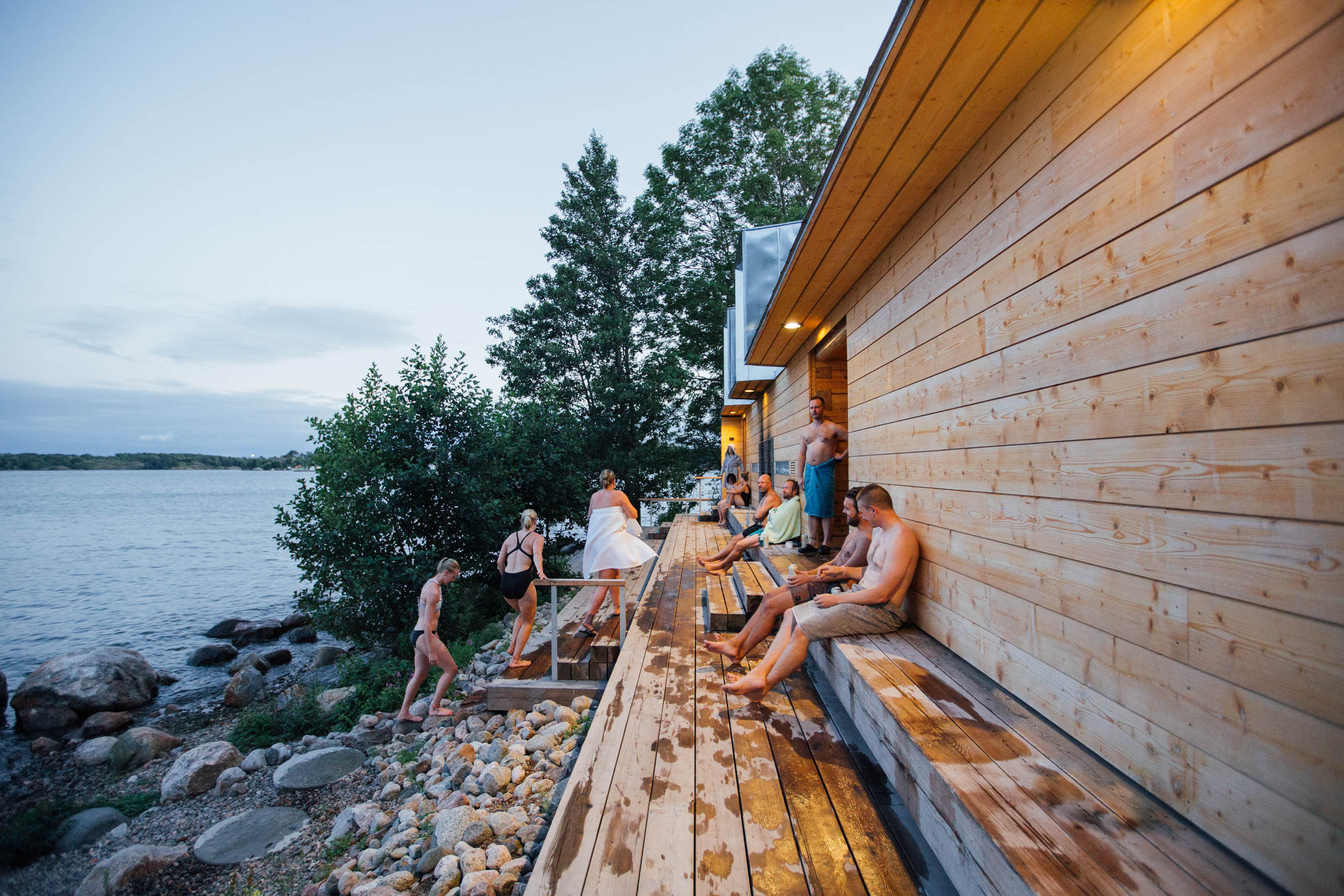 People cooling off on the porch of a sauna be the Baltic Sea