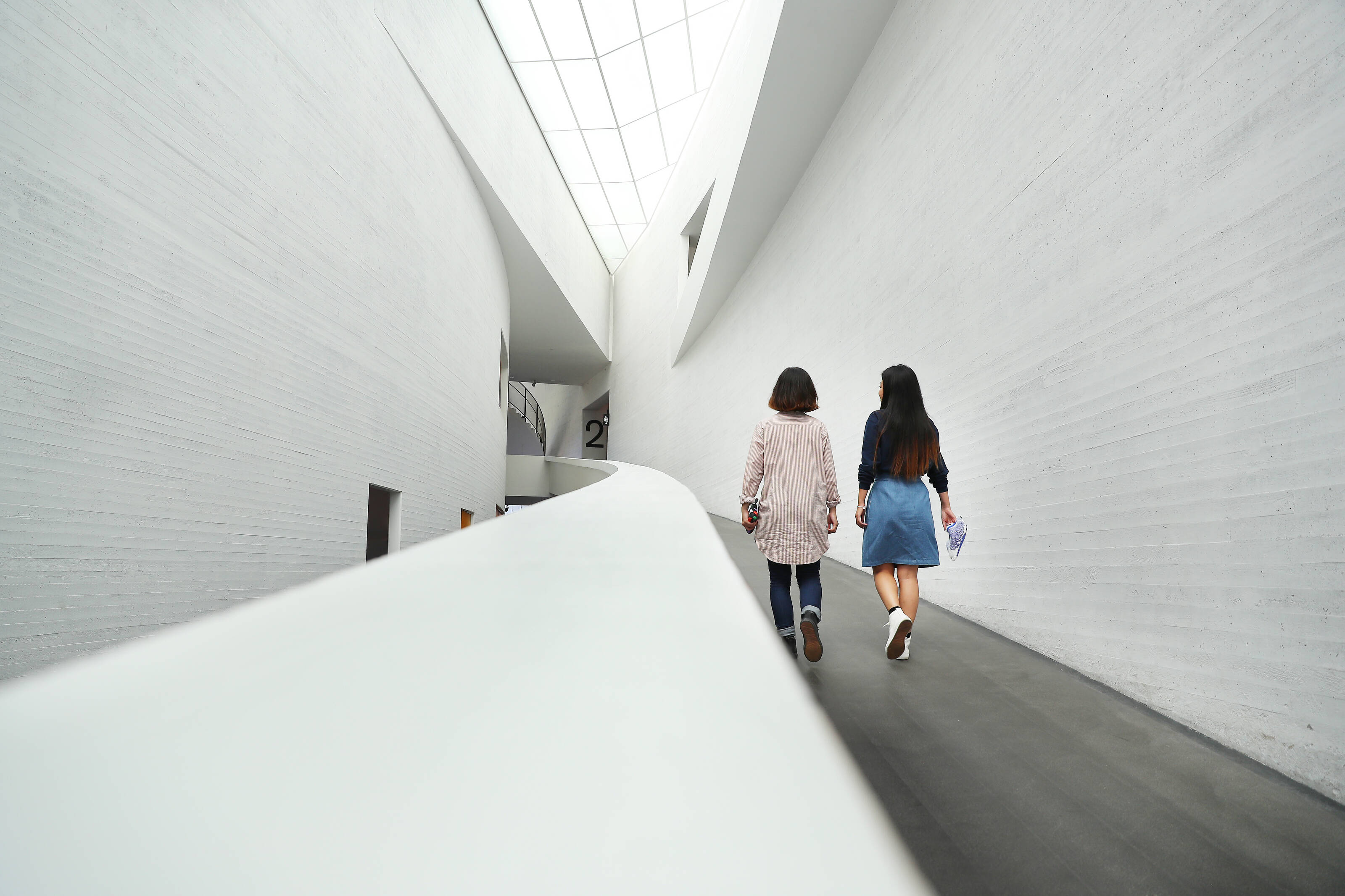 Two people walking in a corridor of a museum