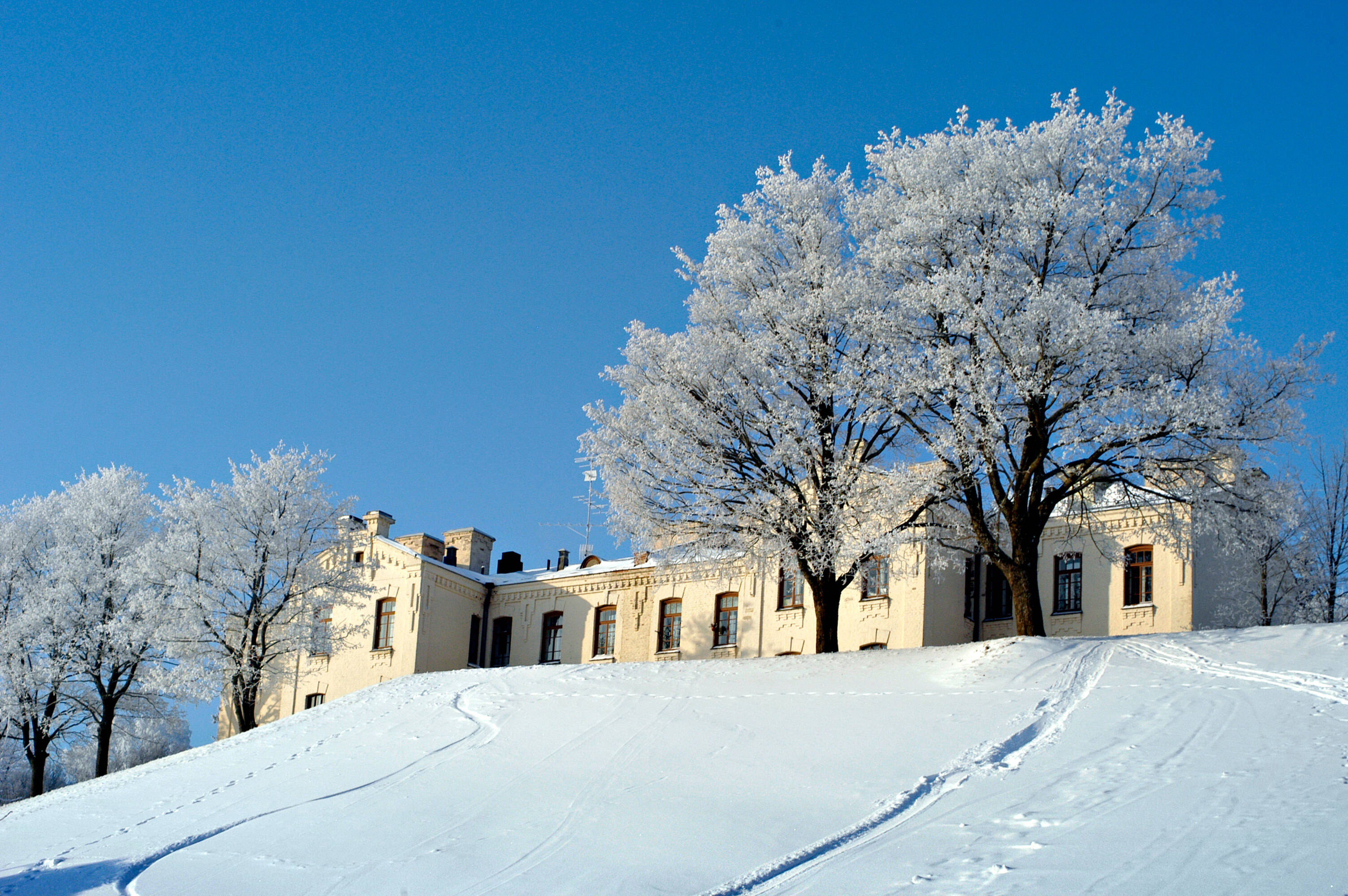 A white beautiful snow-covered building on top of a hill in an old fortress in Lappeenranta.