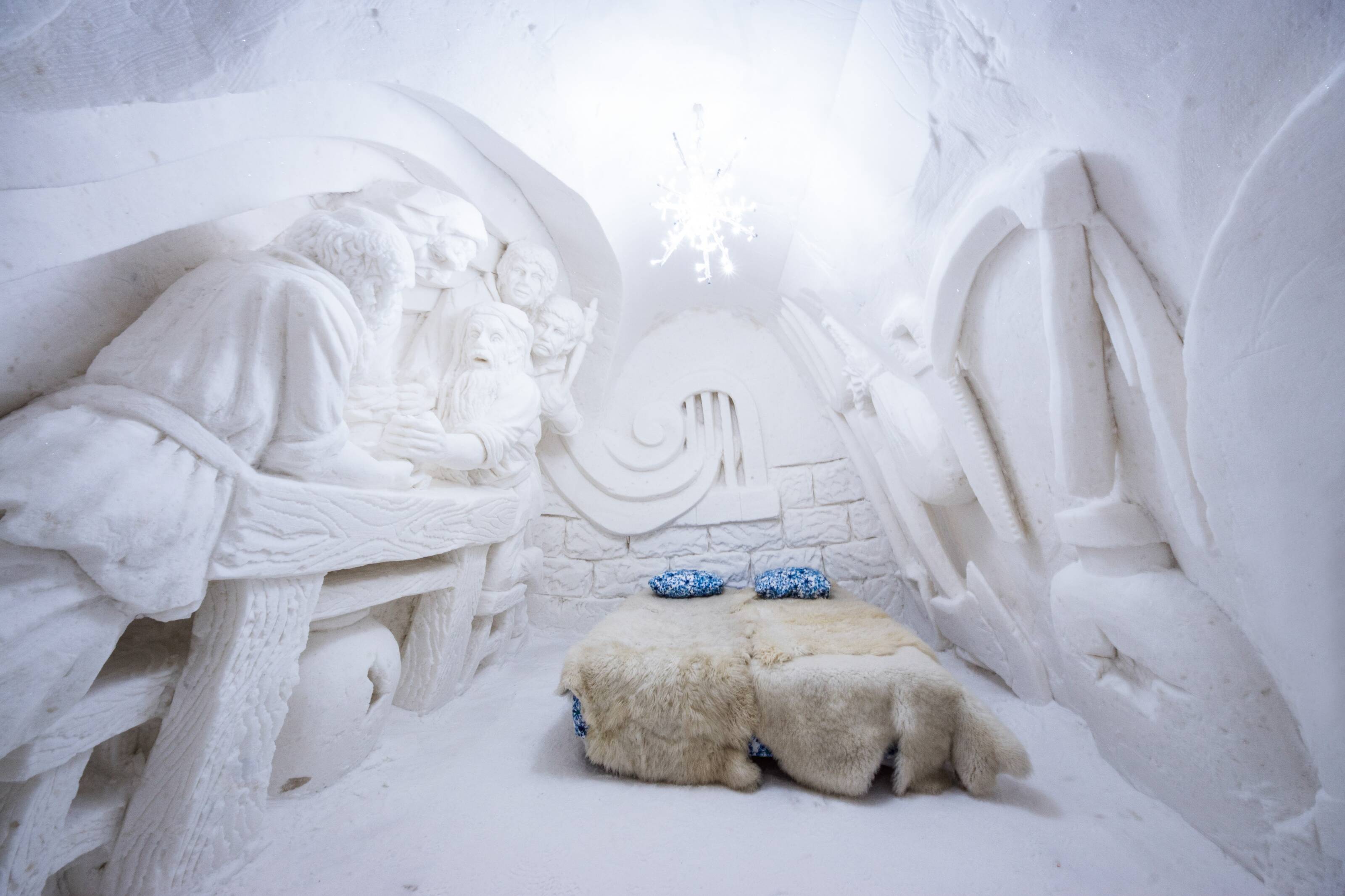The interior of a snow hotel room with snow sculpture decorations.