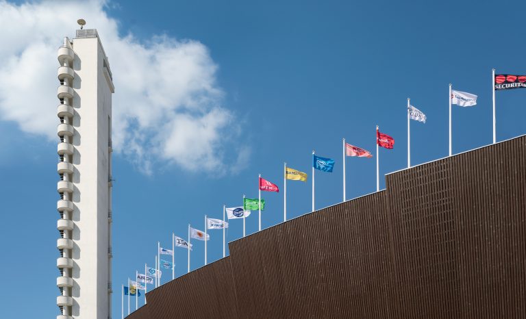 Colourful flags wave along the top of the newly-renovated, functionalist-style Helsinki Olympic Stadium. 
