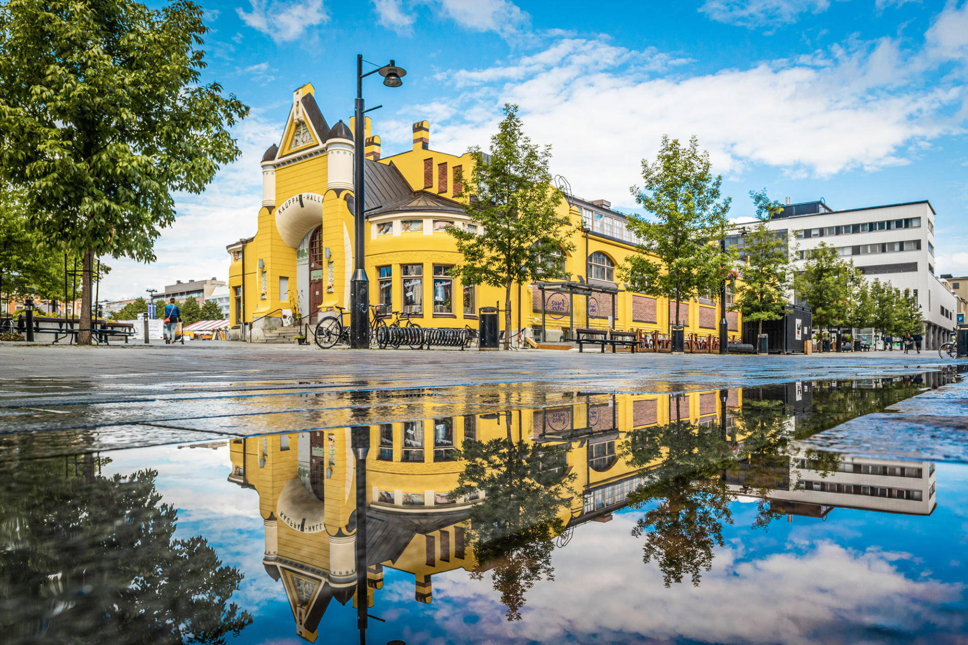 A yellow Art Nouveau-style market hall on Kuopio Market Square in Finland.