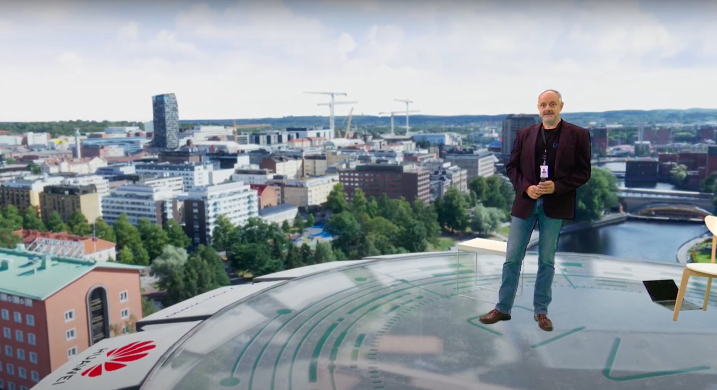 Man standing on top of a high building overlooking Tampere city.